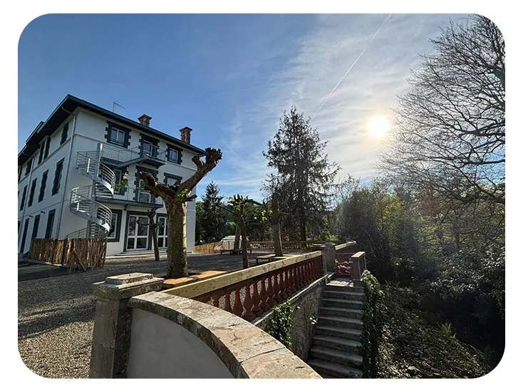 Bâtiment principal et rampe d'accès pavée à contre-jour, en hiver