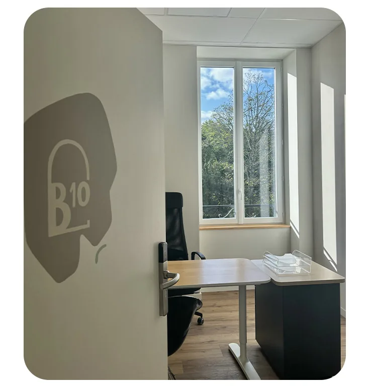 Bureau privé B10 : plan de travail, chaise et fenêtre ouvrant sur le parc