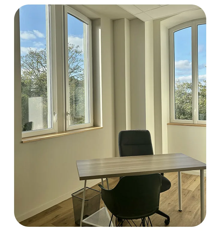 Bureau d'angle à deux fenêtres, table blanche et fauteuil de travail