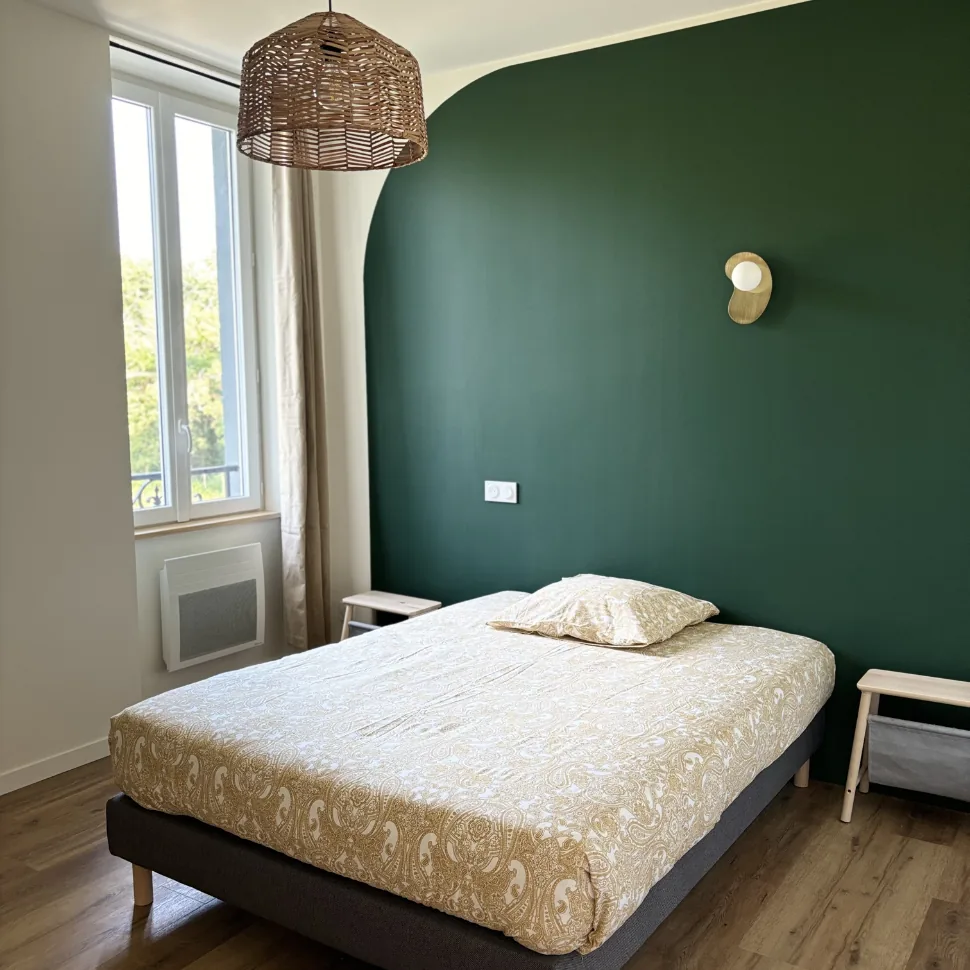 coliving-chambre-lit-double-le-chateau-bayonne Chambre avec lit double, mur vert foncé et suspension en osier